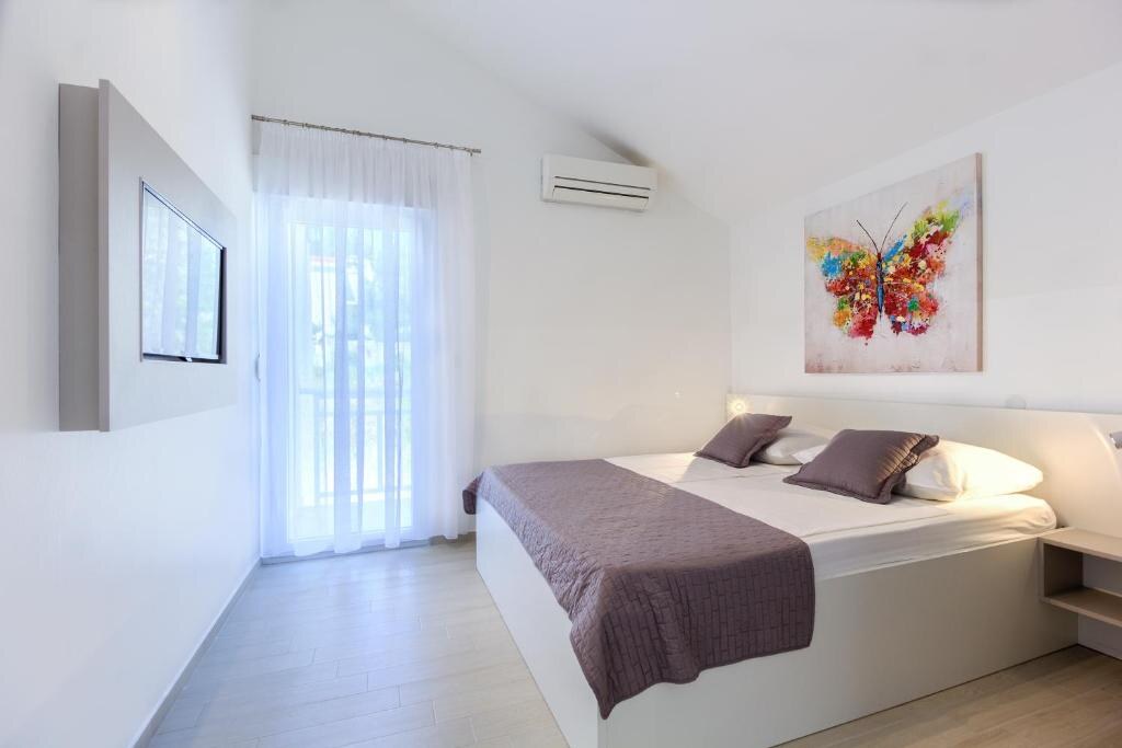 Modern white bedroom with air conditioning and flat-screen TV
